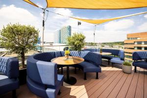 a patio with blue chairs and tables on a roof at Hotel Haarhuis in Arnhem
