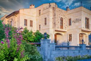 a large stone building with a sign on it at Flavia Cappadocia Hotel in Uçhisar