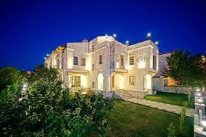 a large white building with lights on it at night at Flavia Cappadocia Hotel in Uçhisar +30 photos