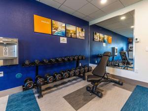 a gym with a row of exercise equipment on a blue wall at Comfort Inn Hanford Lemoore in Hanford