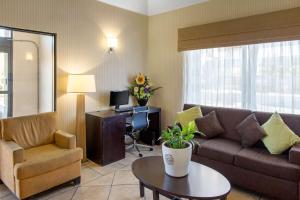 a living room with a couch and a chair and a desk at Sleep Inn & Suites Bakersfield North in Bakersfield