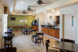 um restaurante com mesas e cadeiras e uma cozinha em Sleep Inn & Suites Bakersfield North em Bakersfield