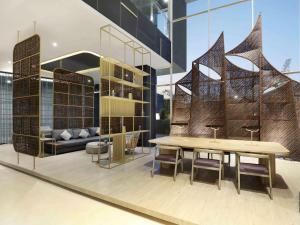 a dining room with a table and chairs in a building at Mercure Makassar Nexa Pettarani in Makassar