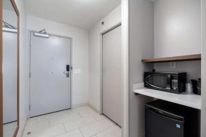a small kitchen with a door and a microwave at Sleep Inn & Suites Tempe ASU Campus in Tempe