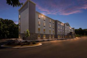 un montage d'un immeuble d'appartements au crépuscule dans l'établissement WoodSpring Suites Lynchburg VA, à Lynchburg