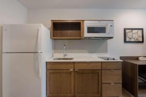 a kitchen with a white refrigerator and a microwave at WoodSpring Suites Lynchburg VA in Lynchburg