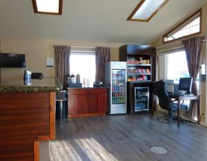 een kamer met een keuken met een koelkast en een bureau bij Rodeway Inn & Suites in Ontario