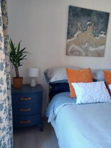 a bedroom with a bed and a nightstand with a plant at The Fuzzy Duck in Broughty Ferry