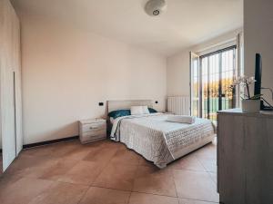 ein Schlafzimmer mit einem Bett und einem großen Fenster in der Unterkunft Appartamento Incantevole a 100metri dal mare e vicino a pista ciclabile in Imperia