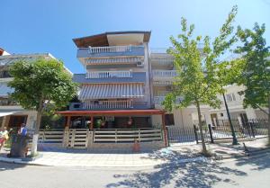 a tall building with a fence in front of it at APARTMENTS HARIS in Olympiaki Akti