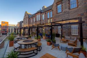 um pátio com mesas e cadeiras em frente a um edifício em BrewDog DogHouse Edinburgh em Edimburgo