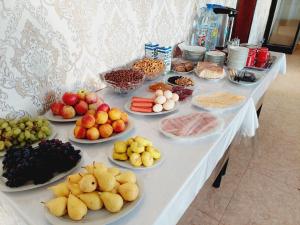 a table with many plates of fruits and vegetables on it at Samarabonu Hotel in Samarkand