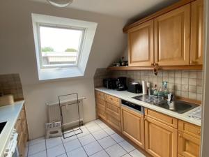a kitchen with wooden cabinets and a sink and a window at Business-Apartment Boltentor in Emden