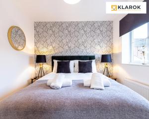 ピーターバラにあるLONG STAYS 30pct OFF - Beautiful 3 Bed & Parking By Klarok Short Lets & Serviced Accommodationのベッドルーム1室(大型ベッド1台、ランプ2つ付)
