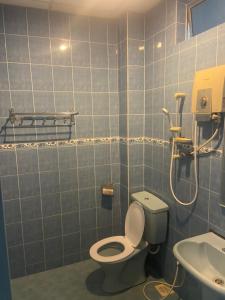 a blue tiled bathroom with a toilet and a sink at SURIA BEACH RESORT Pangkor in Pangkor