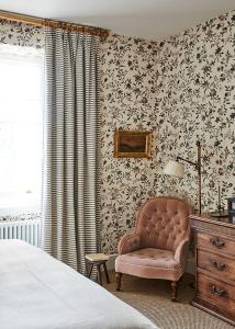 a bedroom with a bed and a chair and a dresser at The Bradley Hare in Maiden Bradley