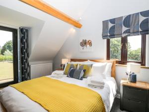 a bedroom with a bed with a yellow blanket at Petals Patch in Cheltenham