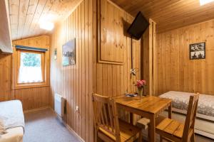 a wooden room with a wooden table and a bed at B&B Pranzaira in Vicosoprano