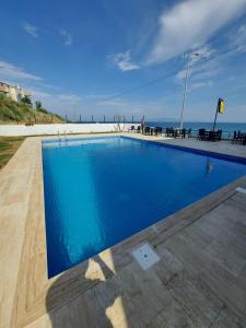 a swimming pool with blue water and a beach at Choras Butik Otel in Şarköy