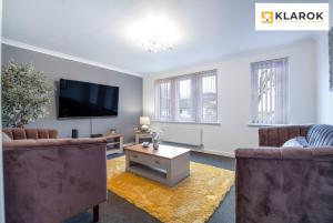 a living room with two couches and a flat screen tv at LONG STAYS 30pct OFF - Spacious 4Bed - Sports Channels - Parking By Klarok Short Lets & Serviced Accommodation in Peterborough