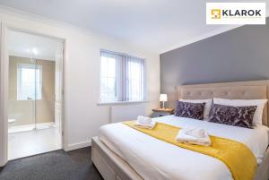 a bedroom with a large bed with towels on it at LONG STAYS 30pct OFF - Spacious 4Bed - Sports Channels - Parking By Klarok Short Lets & Serviced Accommodation in Peterborough