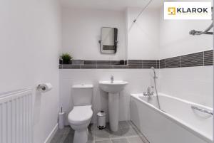 a white bathroom with a toilet and a sink at LONG STAYS 30pct OFF - Superb Central 2Bed Apt with Parking By Klarok Short Lets & Serviced Accommodation in Peterborough