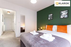 1 dormitorio con 1 cama grande y 2 toallas en LONG STAYS 30pct OFF - Superb Central 2Bed Apt with Parking By Klarok Short Lets & Serviced Accommodation, en Peterborough