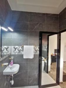 a bathroom with a sink and a mirror at RÉSIDENCE HÔTELIÈRE KAWEROU in Ouagadougou