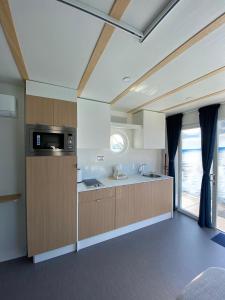 a large kitchen with wooden cabinets and a window at Blue Village in Savigliano