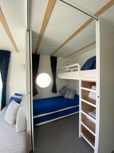 a small room with a bed and bunk beds at Blue Village in Savigliano