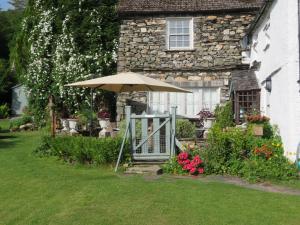 un paraguas en el patio de una casa en Slack Cottage, en Ambleside