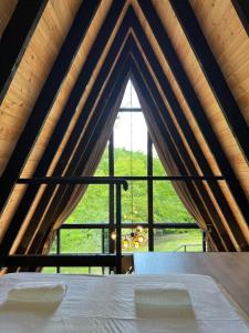 a room with a large window with a bed in front of it at Cottage Sataplia in Kutaisi +143 photos