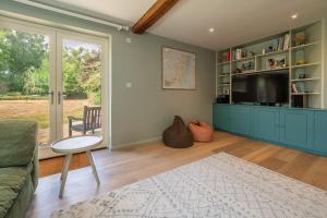 a living room with a couch and a tv at Foxhole Cottage in Stowmarket