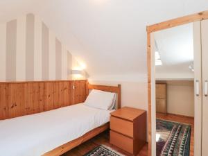 a small bedroom with a bed and a mirror at Heselwood in Lyme Regis