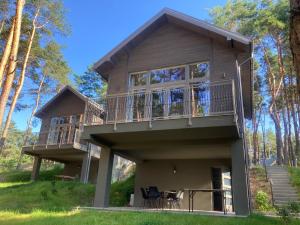 uma casa na floresta com uma varanda em Góra Spokoju Osada klimatyczna-leśna em Inowłódz