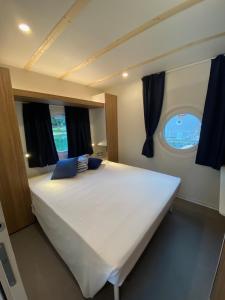 a large white bed in a room with a window at Blue Village in Savigliano