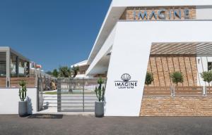 a building with a sign on the side of it at Imagine Luxury Suites in Nikiti