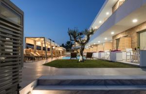 a courtyard of a building with a tree in the middle at Imagine Luxury Suites in Nikiti
