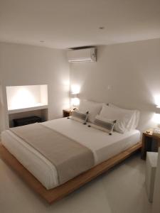 a bedroom with a large white bed with two lamps at Fourteen All Seasons House in Chania