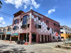 a pink building on the corner of a street at Hotel Bestari in Kuala Lipis