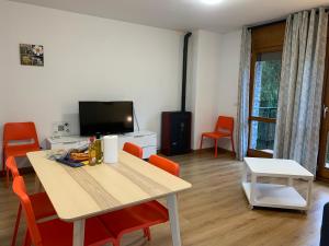 a living room with a table and orange chairs at CAL PAU Guardiola de Berguedà in Guardiola de Berguedà