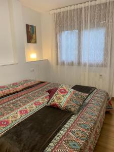 1 dormitorio con 2 camas y almohadas coloridas. en CAL PAU Guardiola de Berguedà, en Guardiola de Berguedà