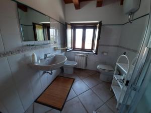 a bathroom with a sink and a toilet and a mirror at B&B Casa Ghiani in Ìsili