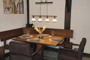 a dining room table with plates and glasses and a chandelier at Hof von Felde in Soltau