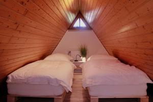 2 Betten in einem Holzzimmer mit Fenster in der Unterkunft Alter Speicher in Soltau