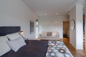 um quarto com uma cama grande e um sofá em Stylish and Spacious Family Home em Reiquiavique