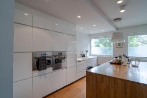 uma cozinha com armários brancos e uma bancada em Stylish and Spacious Family Home em Reiquiavique