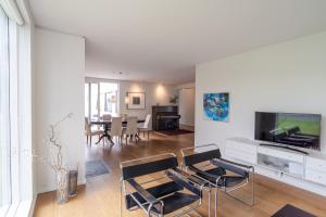 uma sala de estar com uma televisão e uma mesa e cadeiras em Stylish and Spacious Family Home em Reiquiavique