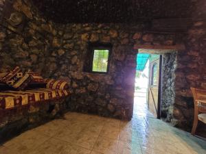a room with a stone wall with a door and a room with a table at Holiday House in Yerevan with Garden and Lovely Views in Yerevan +73 photos