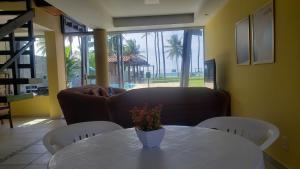 un salon avec une table et un canapé dans l'établissement EnseadaPrime hospedagem beira-mar na Praia Enseada dos Corais em PE, à Cabo de Santo Agostinho